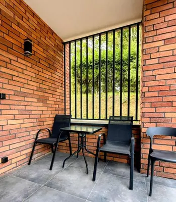 a patio with three chairs and a table and a window at sPokoje in Wieliczka
