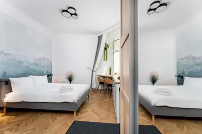 two beds in a room with a desk at Kazimierz Comfort Apartment- Starowiślna 54 in Kraków