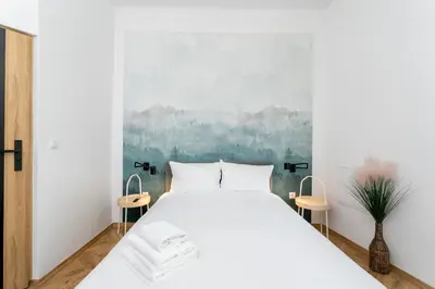a bedroom with a white bed and a painting at Kazimierz Comfort Apartment- Starowiślna 54 in Kraków