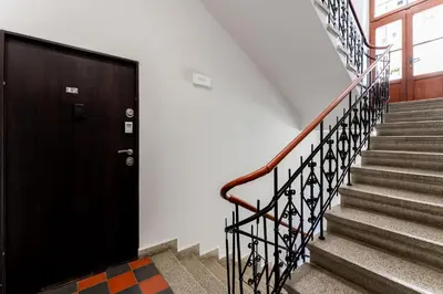 a stairway with a black door and stairs at Kazimierz Comfort Apartment- Starowiślna 54 in Kraków