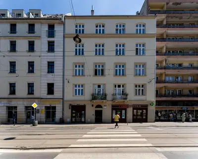 a building with a person walking in front of it at Kazimierz Comfort Apartment- Starowiślna 54 in Kraków
