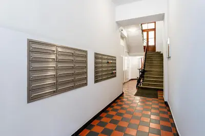 a hallway with white walls and a checkered floor at Kazimierz Comfort Apartment- Starowiślna 54 in Kraków