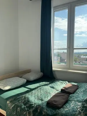 a bedroom with a bed with a window and two towels at TOM PRIVATE room in Kraków
