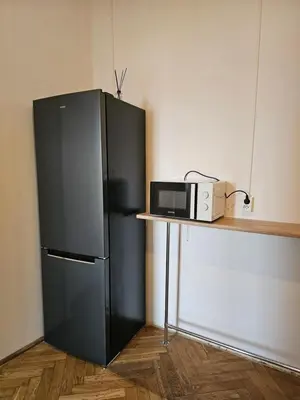 a black refrigerator next to a counter with a microwave at TOM PRIVATE room in Kraków