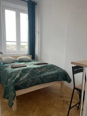 a bed sitting in a room with a window at TOM PRIVATE room in Kraków