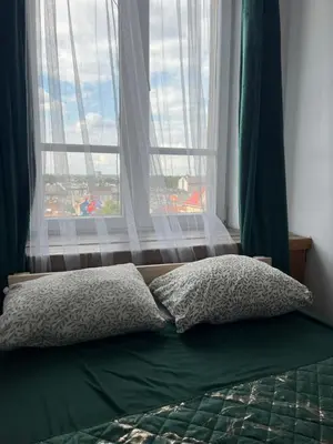 a bed with two pillows in front of a window at TOM PRIVATE room in Kraków