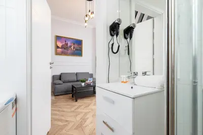 a white bathroom with a sink and a mirror at Świętego Filipa Apartments Cracow by Noclegi Renters in Kraków