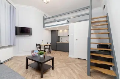 a living room with a staircase and a table at Świętego Filipa Apartments Cracow by Noclegi Renters in Kraków