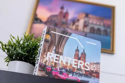 a magazine sitting on a table next to a plant at Świętego Filipa Apartments Cracow by Noclegi Renters in Kraków