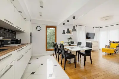 a kitchen and dining room with a table and chairs at Air Conditioned Apartment in Cracow with Parking, Desk and Bathtub by Noclegi Renters in Kraków