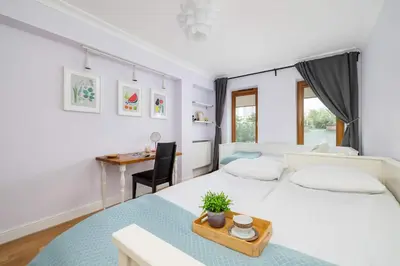 a bedroom with a white bed and a desk at Air Conditioned Apartment in Cracow with Parking, Desk and Bathtub by Noclegi Renters in Kraków