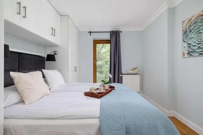 a bedroom with a large white bed with a tray on it at Air Conditioned Apartment in Cracow with Parking, Desk and Bathtub by Noclegi Renters in Kraków