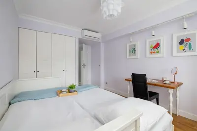 a white bedroom with a bed and a desk at Air Conditioned Apartment in Cracow with Parking, Desk and Bathtub by Noclegi Renters in Kraków