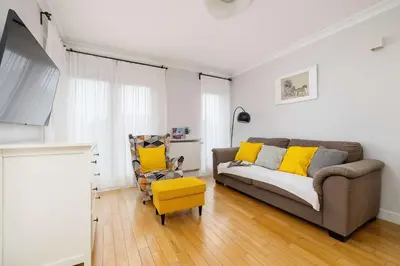 a living room with a couch and a chair at Air Conditioned Apartment in Cracow with Parking, Desk and Bathtub by Noclegi Renters in Kraków