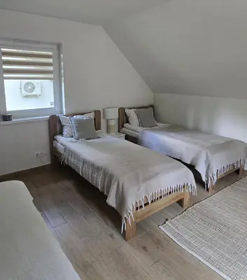two beds sitting in a room with a window at Fundacja Dom Pracy Twórczej PAU Zawoja in Zawoja