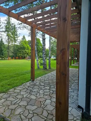 a wooden pergola in a park with a bench at Fundacja Dom Pracy Twórczej PAU Zawoja in Zawoja