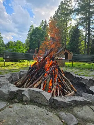 a fire pit with a pile of logs at Fundacja Dom Pracy Twórczej PAU Zawoja in Zawoja