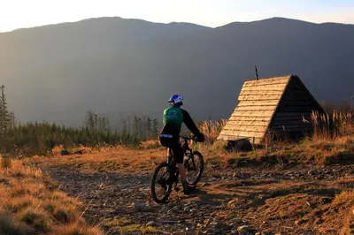 a person riding a bike down a dirt road at Fundacja Dom Pracy Twórczej PAU Zawoja in Zawoja