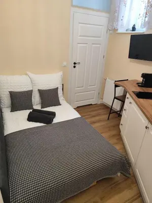 a black and white bed in a room with a desk at Capsule 12- Old Town , Steps to the Station , Maximum Convenience in Kraków