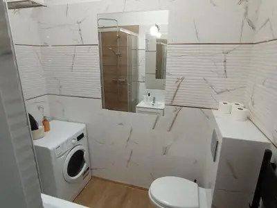 a white bathroom with a toilet and a sink at Capsule 12- Old Town , Steps to the Station , Maximum Convenience in Kraków