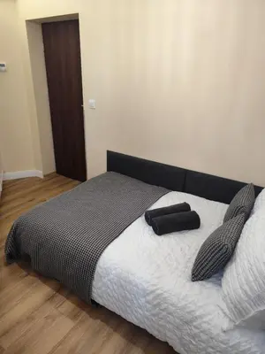 a bedroom with a bed with a black and white comforter at Capsule 12- Old Town , Steps to the Station , Maximum Convenience in Kraków