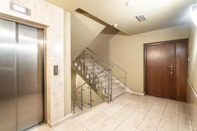 a hallway with a spiral staircase and a wooden door at RentPlanet - Apartament Kazimierza Wielkiego in Kraków