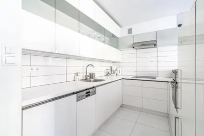 a white kitchen with white cabinets and a sink at RentPlanet - Apartament Kazimierza Wielkiego in Kraków