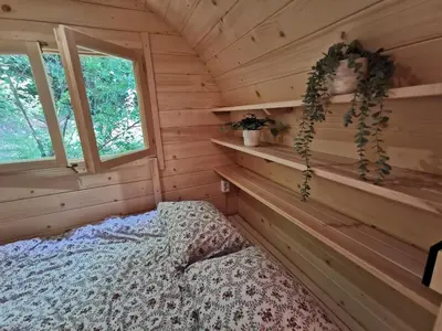 a bedroom with a bed in a wooden cabin at Hope Mountain Escape Poland, Charming Barrel House in Szczawa