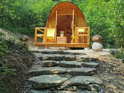 a wooden cabin with chairs and a stone path at Hope Mountain Escape Poland, Charming Barrel House in Szczawa