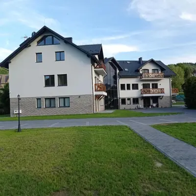 a white house with a black roof at Apartament pod Groniem in Zawoja