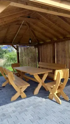 a picnic table and two chairs under a pavilion at Apartament pod Groniem in Zawoja