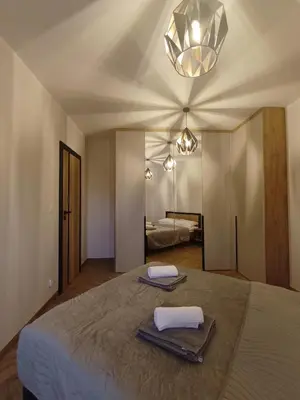 a bedroom with a bed with towels and a mirror at Apartament pod Groniem in Zawoja