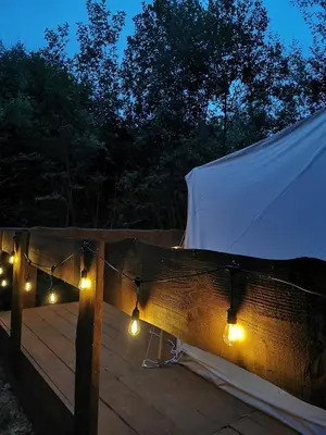 a wooden deck with lights and a tent at Hope Mountain Escape Poland, Awesome Glamping Tent in Szczawa