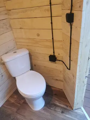 a bathroom with a toilet in a wooden wall at Hope Mountain Escape Poland, Awesome Glamping Tent in Szczawa