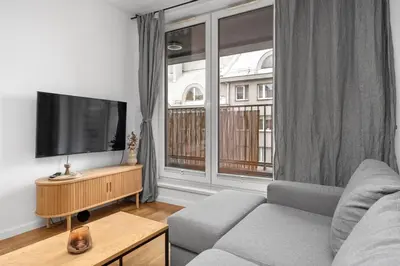 a living room with a couch and a large window at Cricoteque Residence - Luxury 1BR Riverside Suite in Kraków