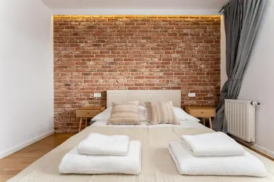 a bedroom with a bed with a brick wall at Cricoteque Residence - Luxury 1BR Riverside Suite in Kraków