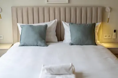 a large white bed with blue pillows in a room at Kalwaryjska Elegant Stay Studios by BookingHost in Kraków
