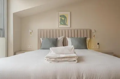 a white bed with a pile of towels on it at Kalwaryjska Elegant Stay Studios by BookingHost in Kraków