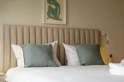 a bed with blue and white pillows in a room at Kalwaryjska Elegant Stay Studios by BookingHost in Kraków
