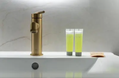 a gold water faucet and two glasses on a sink at Kalwaryjska Elegant Stay Studios by BookingHost in Kraków