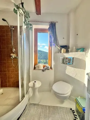 a bathroom with a toilet and a shower and a window at Dom Ponad Wsią in Zawoja