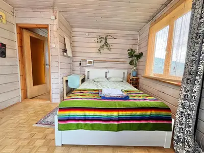 a bedroom with a bed in a room with wooden walls at Dom Ponad Wsią in Zawoja