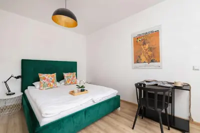 a small bedroom with a green bed and a desk at Stylish Apartment Dietla with Balcony in Kraków by Noclegi Renters in Kraków