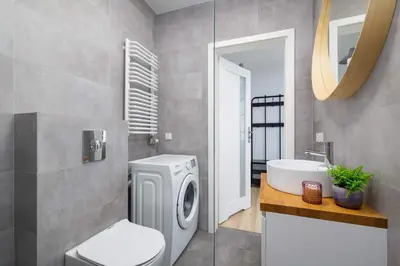 a bathroom with a washing machine and a sink at Stylish Apartment Dietla with Balcony in Kraków by Noclegi Renters in Kraków