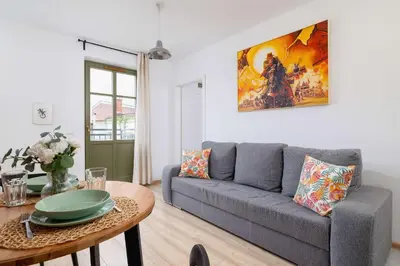 a living room with a couch and a table at Stylish Apartment Dietla with Balcony in Kraków by Noclegi Renters in Kraków