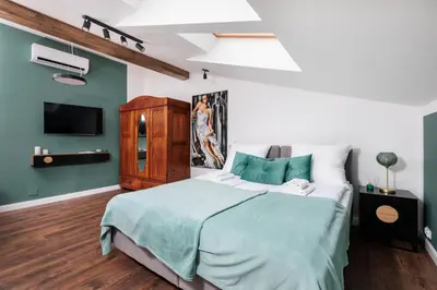 a bedroom with a large bed and a tv at The Vitrail Apartments - by Upstairs in Kraków