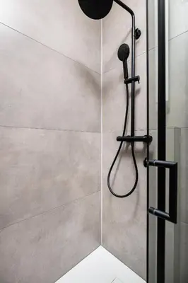 a shower with a shower head in a bathroom at The Vitrail Apartments - by Upstairs in Kraków