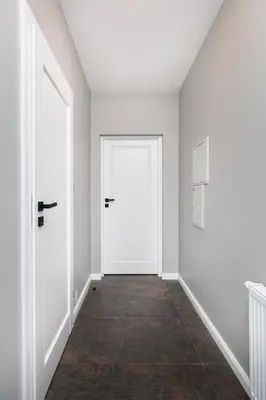 an empty hallway with white walls and doors at The Vitrail Apartments - by Upstairs in Kraków