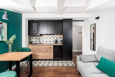 a kitchen and living room with a couch and a table at The Vitrail Apartments - by Upstairs in Kraków