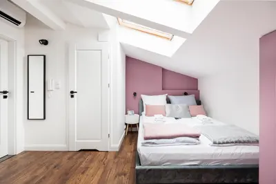 a bedroom with a large bed with pink walls at The Vitrail Apartments - by Upstairs in Kraków